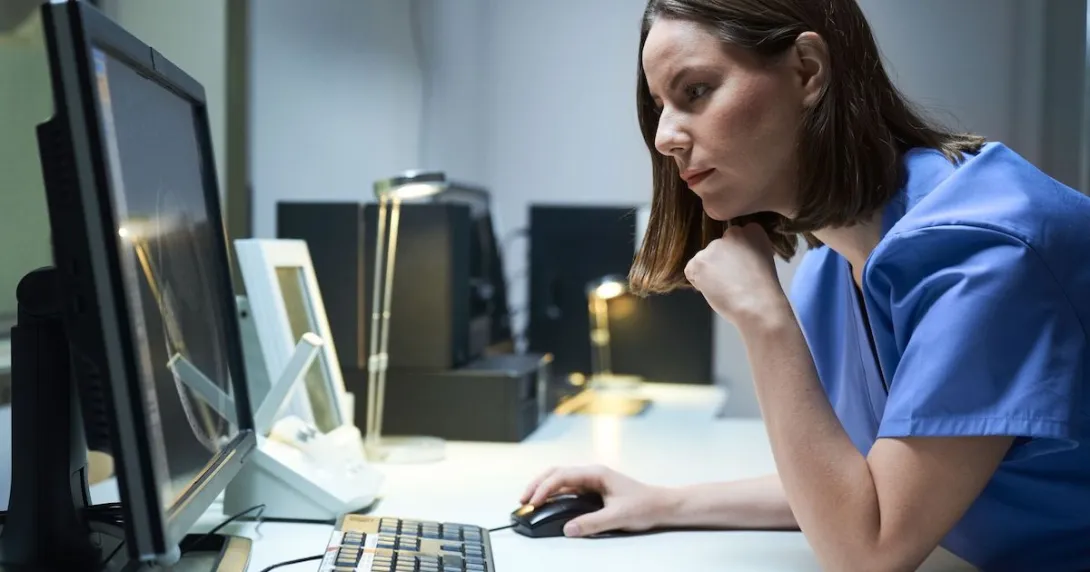 Healthcare provider sitting at a desk while looking at a computer