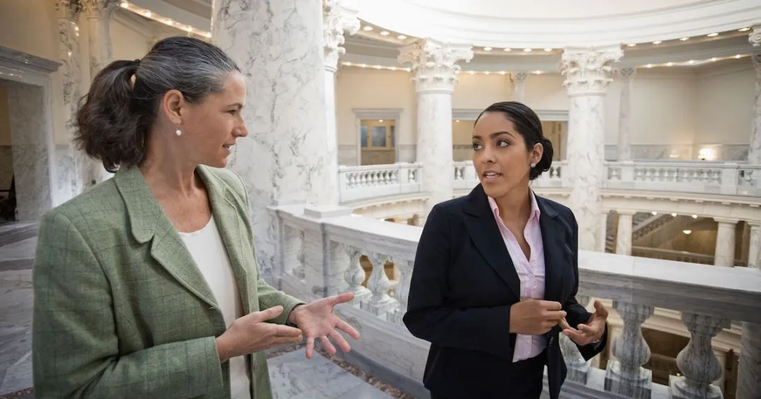 Two people walking through a federal building while talking to each other