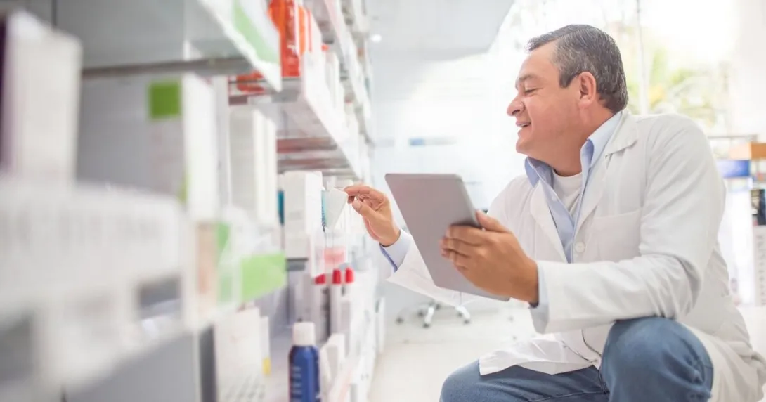 A pharmacist doing an inventory in a drug store using a digital tablet